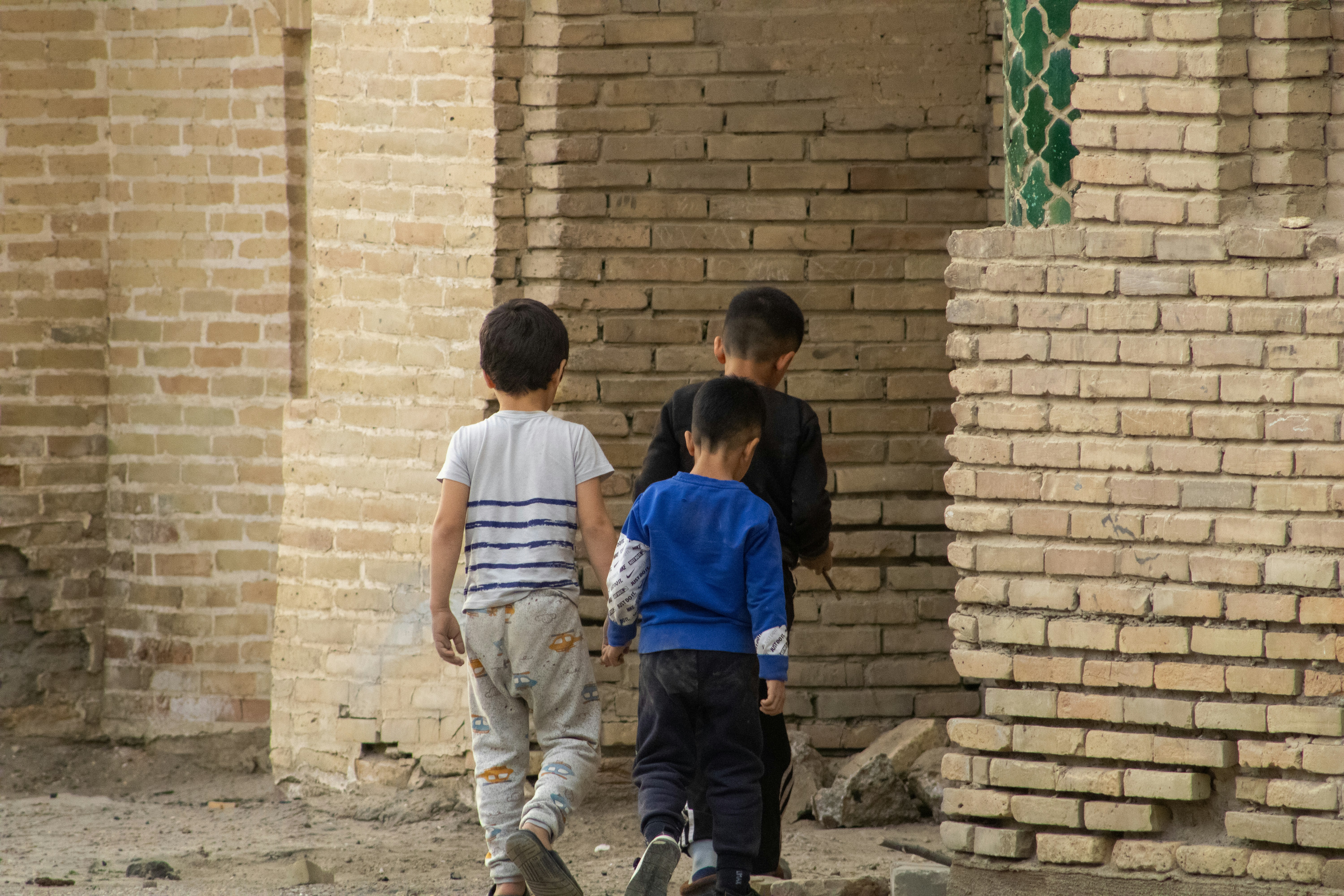 Afghan children walking through a community learning environment